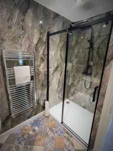 a shower with a glass door in a bathroom at The Woodlands in Sandsend +27 photos