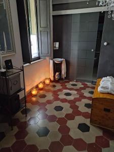 uma casa de banho com piso em azulejo e velas em La casetta sul Piazzone em Castelnuovo di Val di Cecina