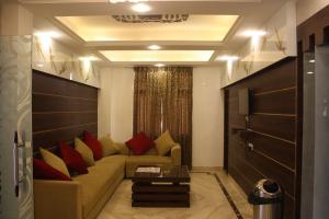 soggiorno con divano e cuscini rossi di Hotel Golden sky a Lucknow