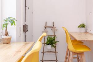 a dining room with yellow chairs and a table at The Local Guest House Lisbon in Lisbon +28 photos