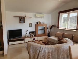 a living room with a couch and a flat screen tv at Bougenville in Kampor