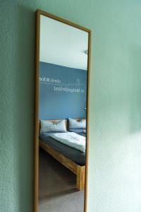 a mirror reflection of a bed in a bedroom at Hotel Check-Rhein - Self Check-in in Neuenburg am Rhein