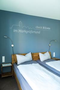 1 dormitorio con 2 camas y pared azul en Hotel Check-Rhein - Self Check-in en Neuenburg am Rhein