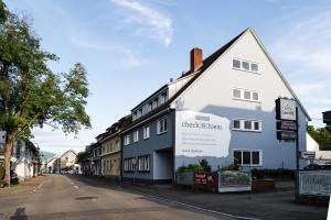 ein weißes Gebäude mit einem Schild an der Seite in der Unterkunft Hotel Check-Rhein - Self Check-in in Neuenburg am Rhein