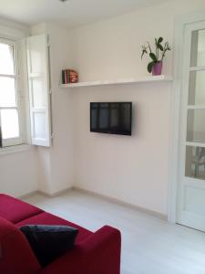 a living room with a red couch and a tv at Casa Umberto I in Catania