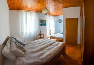 1 dormitorio con 1 cama grande y techo de madera en Villa Maria, en Koper