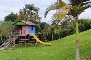 a small house with a slide and a playground at APTO WIFI+ AIRE AC +PISCINAS +JACUZZI +TOBOGAN+BBQ in La Tebaida