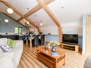 a living room with a white couch and a tv at Cointree in Sturminster Newton