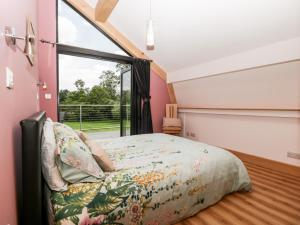 Un dormitorio con una cama y una ventana grande en Cointree, en Sturminster Newton