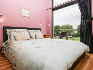 een slaapkamer met een bed en een groot raam bij Cointree in Sturminster Newton +30 foto's