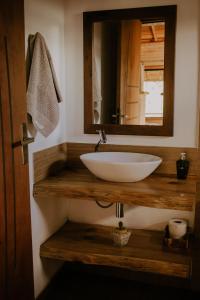 a bathroom with a white sink and a mirror at Chalés Recanto da Mantiqueira in Gonçalves