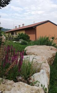 a house with purple flowers in front of a yard at B&B Cà Montemezzano in Verona