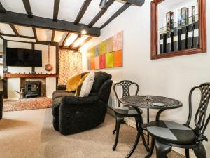 a living room with a chair and a table at Cariad Cottage in Ludlow