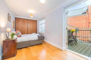 a bedroom with a bed and a balcony at Nelson's Pad - Trafalgar Square - by Frankie Says in London