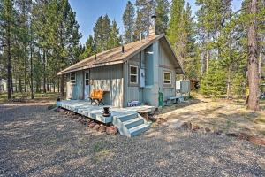 a blue tiny house in the middle of a forest at High Lakes Hideaway La Pine Fishing Cabin! in La Pine