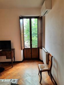 Habitación vacía con ventana, silla y escritorio. en Palazzo Calocci appartamenti in Assisi, en Asís