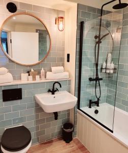 a bathroom with a sink and a mirror at Greyhound Hotel in Sutton