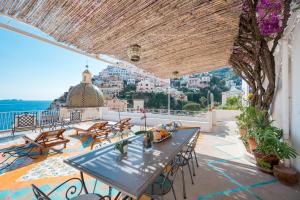 eine Terrasse mit Tischen und Stühlen und Stadtblick in der Unterkunft Villa Giusy in Positano