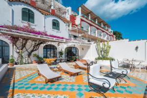 a patio area with chairs, tables and umbrellas at Villa Giusy in Positano