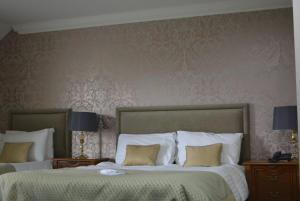 a bedroom with two beds and a wall with wallpaper at Stallingborough Grange Hotel in Stallingborough