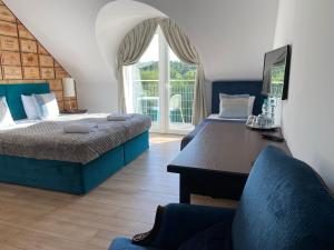 a bedroom with two beds and a desk and a window at Winnica Nawrot in Mechelinki
