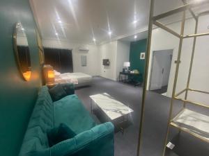 uma sala de estar com um sofá verde e uma cama em MUSE Boutique Hotel em Enugu