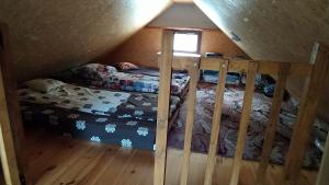 a attic room with two beds and a window at Podlaskie Żuczki in Żuki