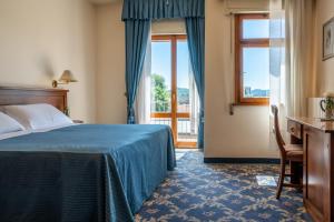 Habitación de hotel con cama y ventana en Hotel Terme Posta Padova HOTEL RC12, en Abano Terme