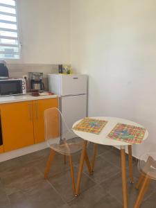 La caraïbe dans la station balnéaire في سانت فرانسوا: مطبخ صغير مع طاولة وكرسي