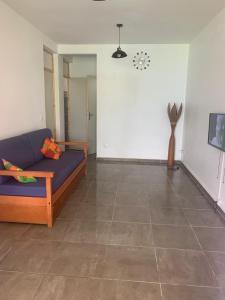 La caraïbe dans la station balnéaire في سانت فرانسوا: غرفة معيشة مع أريكة زرقاء وأرضية من البلاط