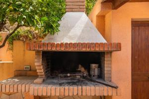 un horno de ladrillo al aire libre con techo en Casa Anna, en Marongiu