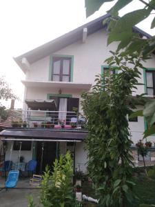 een wit huis met een balkon met blauwe stoelen bij Snezana home in Vranje