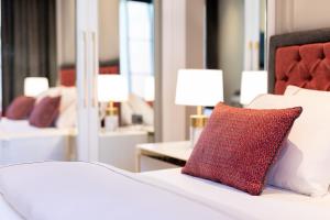 a bedroom with a white bed with a red pillow at Motif Hotel Çeşme in Çeşme