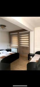 a bedroom with two beds and two windows at Motel Luxor in Visoko