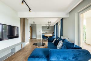 a living room with a blue couch and a table at Leeloo in Człuchów