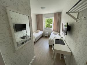 um quarto de hotel com uma cama e um espelho em Hotell Luspen em Storuman