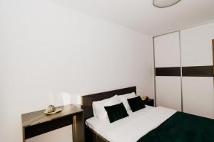 a bedroom with a bed with black and white sheets at Homeland Apartments VIVA in Cluj-Napoca
