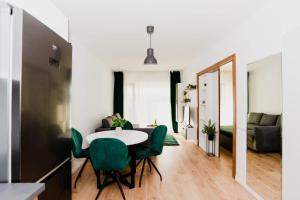 a dining room with a table and green chairs at Homeland Apartments VIVA in Cluj-Napoca