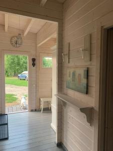 a wooden room with a dog looking out the door at Māja pie Ziedu laivas in Plieņciems