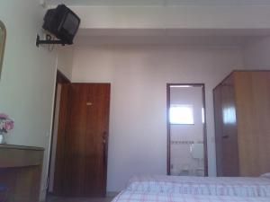 a bedroom with a bed and a tv on the wall at Residencial Nosso Paraiso in Quarteira
