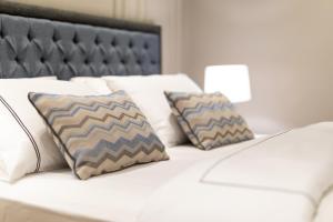 a white bed with two pillows on top of it at Motif Hotel Çeşme in Çeşme