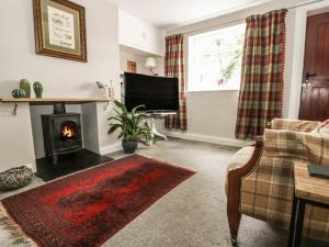 a living room with a fireplace and a tv at Wren's Nest in Thirsk