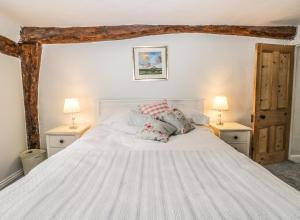 サースクにあるWren's Nestのベッドルーム(白い大型ベッド、ランプ2つ付)