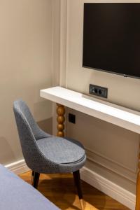 a room with a desk with a tv and a chair at Motif Hotel Çeşme in Çeşme