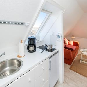 eine Küche mit einem Waschbecken und einem Fenster in der Unterkunft Wohnung Studio in Westerland