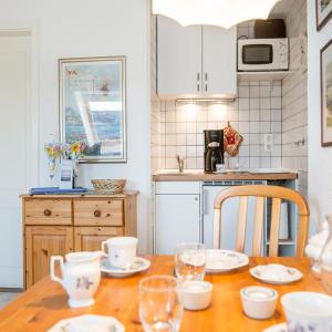 eine Küche mit einem Holztisch mit Tellern und Gläsern darauf in der Unterkunft Wohnung Ost in Westerland