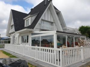 a white house with a porch with glass doors at Den Hoge Doorn in Harelbeke