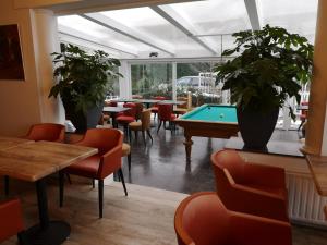 a restaurant with tables and a pool table at Den Hoge Doorn in Harelbeke