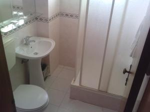 a bathroom with a toilet and a sink and a shower at Residencial Nosso Paraiso in Quarteira +37 photos