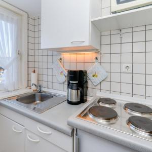 a kitchen with a sink and a coffee maker on a counter at Wohnung West in Westerland